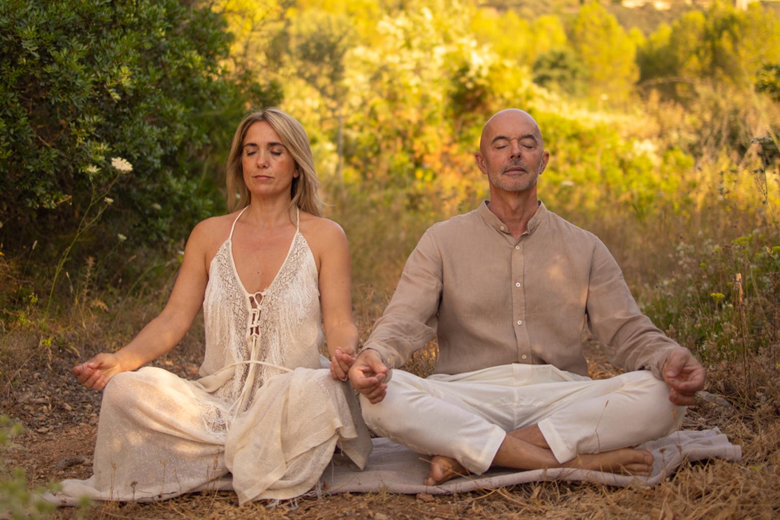 A couple practices Tantra meditation in nature, breathing together to awaken energy, deepen connection, and cultivate presence in a serene setting.