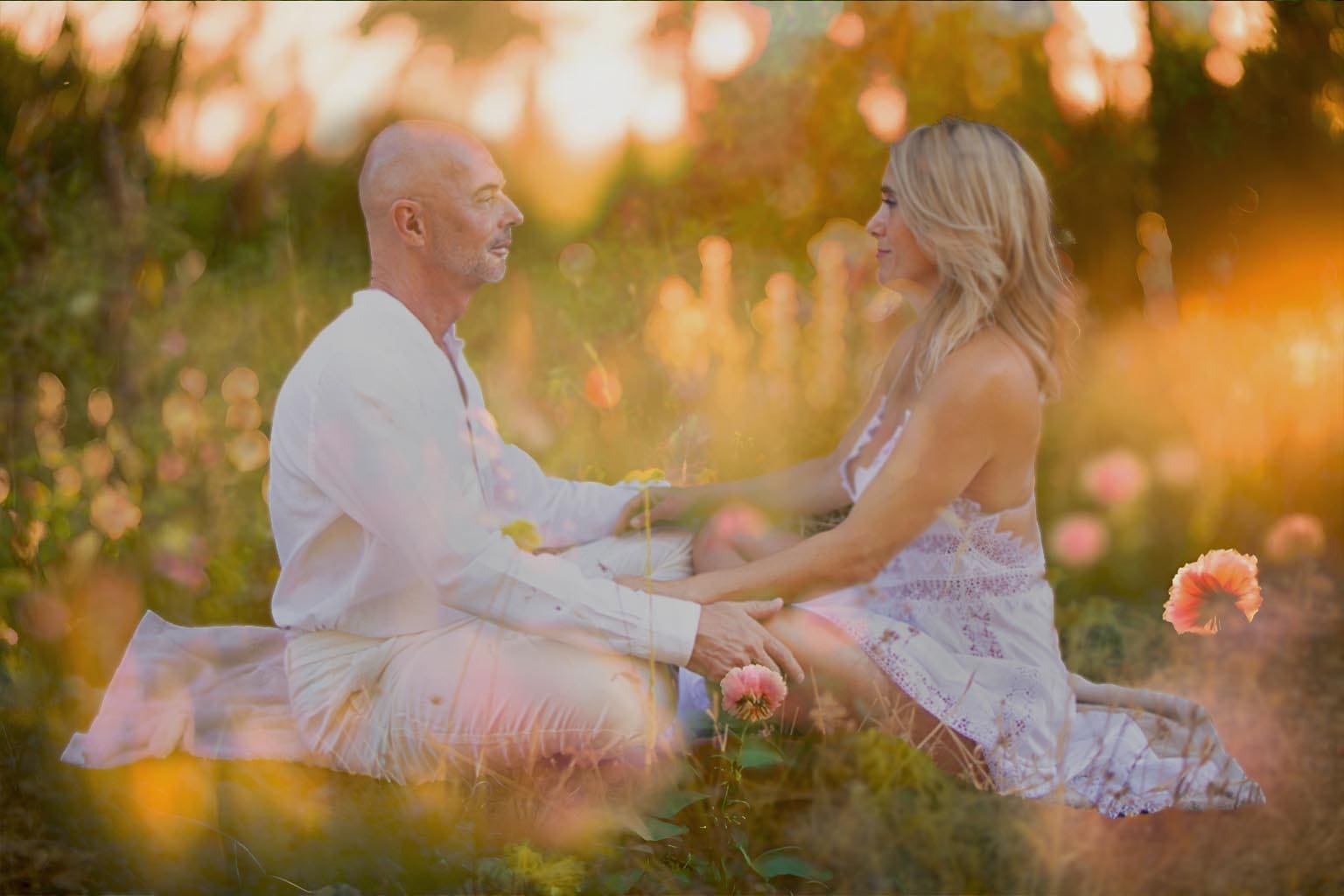 Mónica and Peter, founders of Connective Tantra School, sitting face to face in a mindful outdoor practice at sunset