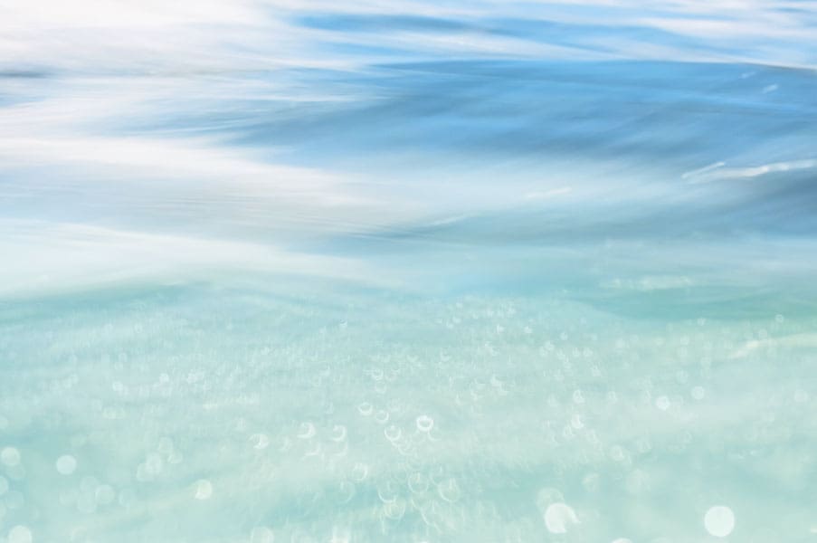 AGUA: ejercicios de respiración tántrica para cada elemento por Connective Tantra School Imagen de foco suave de agua turquesa clara que se mezcla con un horizonte azul tranquilo, evocando fluidez, emoción y el elemento Agua en la práctica de respiración tántrica.